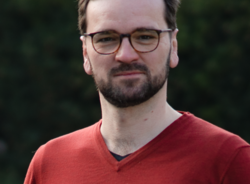 Grüner Fraktionär Cornelius Hantscher, im Hintergrund unscharfe dunkelgrüne Vegetation