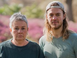 Grüne Fraktionsvorsitzende Suse Stobbe und Julian Schlumberger, vor unscharfem rötlich-grünen Hintergrund