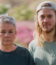 Grüne Fraktionsvorsitzende Suse Stobbe und Julian Schlumberger, vor unscharfem rötlich-grünen Hintergrund