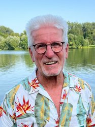 Horst Roth vor einem See mit Bäumen am Horizont