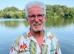 Horst Roth vor einem See mit Bäumen am Horizont