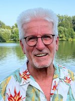 Horst Roth vor einem See mit Bäumen am Horizont