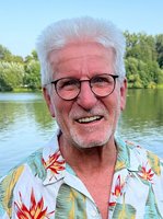 Horst Roth vor einem See mit Bäumen am Horizont