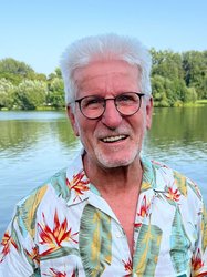 Horst Roth vor einem See mit Bäumen am Horizont