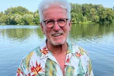 Horst Roth vor einem See mit Bäumen am Horizont