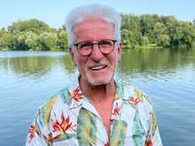 Horst Roth vor einem See mit Bäumen am Horizont