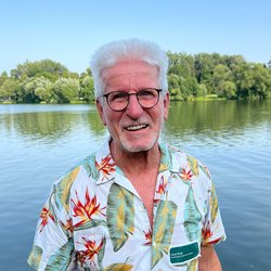 Horst Roth vor einem See mit Bäumen am Horizont