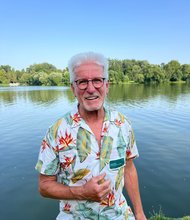 Horst Roth vor einem See mit Bäumen am Horizont