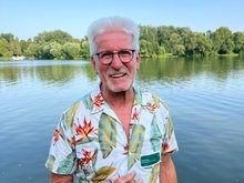 Horst Roth vor einem See mit Bäumen am Horizont