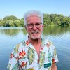 Horst Roth vor einem See mit Bäumen am Horizont