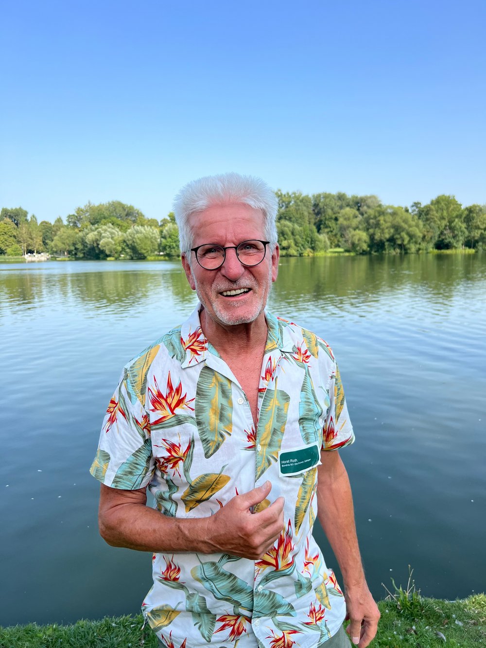 Horst Roth vor einem See mit Bäumen am Horizont