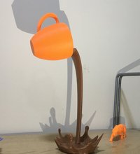 3D-Druck Symbolbild: orangene Tasse die braune Flüssigkeit ausschüttet, vor hellem Hintergrund