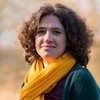 Grüne Fraktionärin Leonie Engelbert, vor unscharfer gelblicher Vegetation