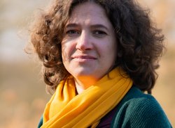 Grüne Fraktionärin Leonie Engelbert, vor unscharfer gelblicher Vegetation