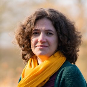 Grüne Fraktionärin Leonie Engelbert, vor unscharfer gelblicher Vegetation