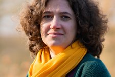 Grüne Fraktionärin Leonie Engelbert, vor unscharfer gelblicher Vegetation