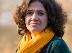 Grüne Fraktionärin Leonie Engelbert, vor unscharfer gelblicher Vegetation