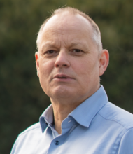 Grüner Fraktionär Dirk Lanwert, vor dunklem Hintergrund