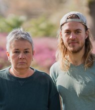 Grüne Fraktionsvorsitzende Suse Stobbe und Julian Schlumberger, vor unscharfem rötlich-grünen Hintergrund