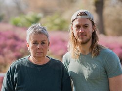 Grüne Fraktionsvorsitzende Suse Stobbe und Julian Schlumberger, vor unscharfem rötlich-grünen Hintergrund