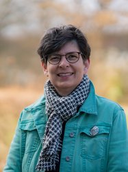 Grüne Fraktionärin Regina Meyer, vor unscharfer gelblicher Vegetation