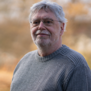 Grüner Fraktionär Michael Höfer, im Hintergrund unscharfe gelbliche Vegetation