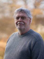 Grüner Fraktionär Michael Höfer, im Hintergrund unscharfe gelbliche Vegetation