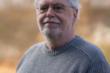 Grüner Fraktionär Michael Höfer, im Hintergrund unscharfe gelbliche Vegetation