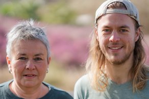 Grüne Fraktionsvorsitzende Suse Stobbe und Julian Schlumberger, vor unscharfer, rötlich-gelber Vegetation