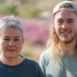 Grüne Fraktionsvorsitzende Suse Stobbe und Julian Schlumberger, vor unscharfer, rötlich-gelber Vegetation