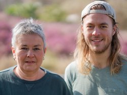 Grüne Fraktionsvorsitzende Suse Stobbe und Julian Schlumberger, vor unscharfer, rötlich-gelber Vegetation