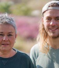 Grüne Fraktionsvorsitzende Suse Stobbe und Julian Schlumberger, vor unscharfer, rötlich-gelber Vegetation