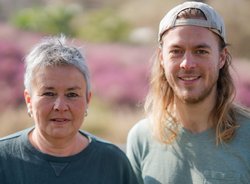 Grüne Fraktionsvorsitzende Suse Stobbe und Julian Schlumberger, vor unscharfer, rötlich-gelber Vegetation