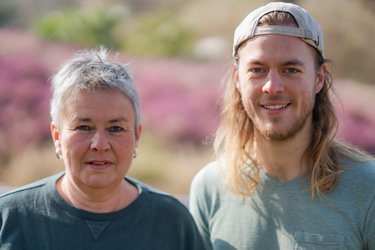 Grüne Fraktionsvorsitzende Suse Stobbe und Julian Schlumberger, vor unscharfer, rötlich-gelber Vegetation
